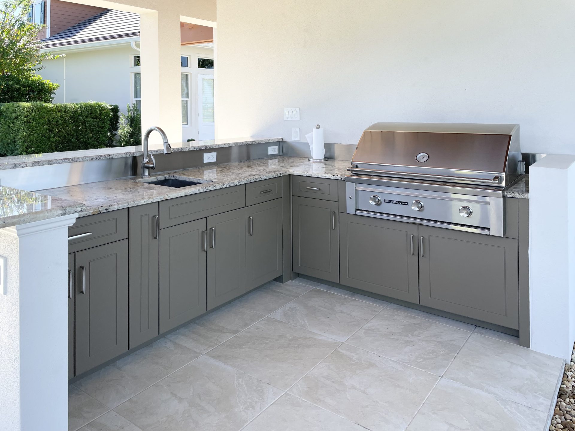 OUTDOOR KITCHEN 37. Custom outdoor kitchen in Lakewood Ranch, FL. Kitchen features slate gray, sport style cabinets. Appliances include Lynx grill and stainless bar pulls.